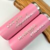 Dos Termo personalizado delgado de color rosa de 590 ml (20 oz) con los nombres Lupita Aguilar y Maribel Mexia en letras plateadas reposan sobre una bandeja de madera.