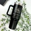 Termo personalizado jumbo con agarradera 1200ml (40oz) con bocetos arquitectónicos y texto, en color negro, colocado entre plantas junto a una libreta.