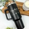 Termo personalizado jumbo con agarradera 1200ml 40oz, decorado con FIDE y dactilología en ASL, sobre una tabla de madera junto a una vela y follaje.