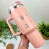 Una mano sostiene un Termo personalizado jumbo con agarradera de 1200 ml (40 oz) en color rosa, con la etiqueta "Sonrisa" y el gráfico de un diente, junto con el nombre Dra. Ketzia D. Sicairos.