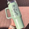Una mano sostiene un Termo personalizado jumbo con agarradera 1200ml 40oz en color verde menta con diseño floral y el nombre Laura Brusela.