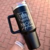 Una mano sostiene un Termo personalizado jumbo con agarradera 1200ml 40oz, con bocetos arquitectónicos y el texto "ARQUI Arturo", destacando este elegante y espacioso termo personalizado.