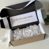 Caja personalizada con 2 diseños kraft mate, rellena de papel blanco y una nota: "Vale por una cuna. Con amor, tus abuelos", para un detalle especial.