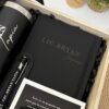 Cuaderno negro personalizado A5 con elástico, etiquetado LIC. BRYAN TAPIA, más bolígrafo y vaso con nota en caja de regalo de madera.