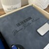Libreta personalizada A5 con broche magnético plateado azul, grabada LIC. EN DERECHO Blanca Benitez Medina, acompañada de bolígrafo azul y vela.