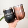 Una mano sostiene dos vasos personalizados de 360 ml del Kit termo vinero 360 ml x2 y caja chica personalizada, etiquetados Armando Padrino y Elizabeth Madrina, ideales para regalar.