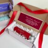 Kit termo delgado 590ml y caja chica personalizada: incluye un termo rojo con nombre, tarjeta con mensaje en español, cinta roja y papel de relleno.