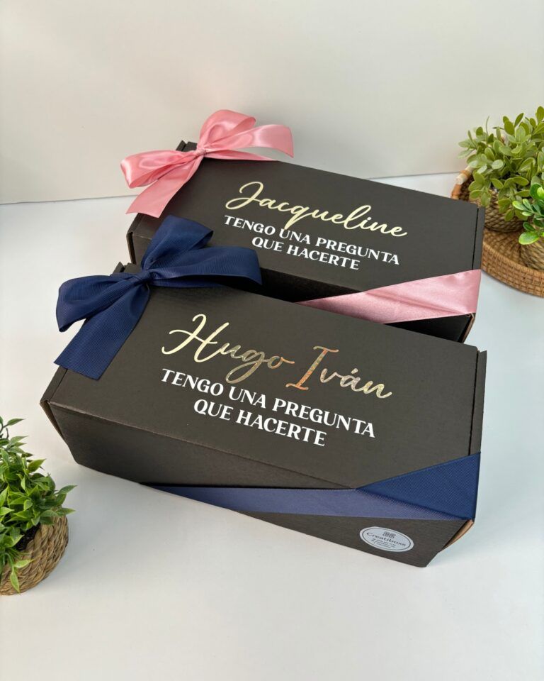 Dos cajas de regalo color negro personalizadas en el exterior con nombre una para mujer y otra para hombre