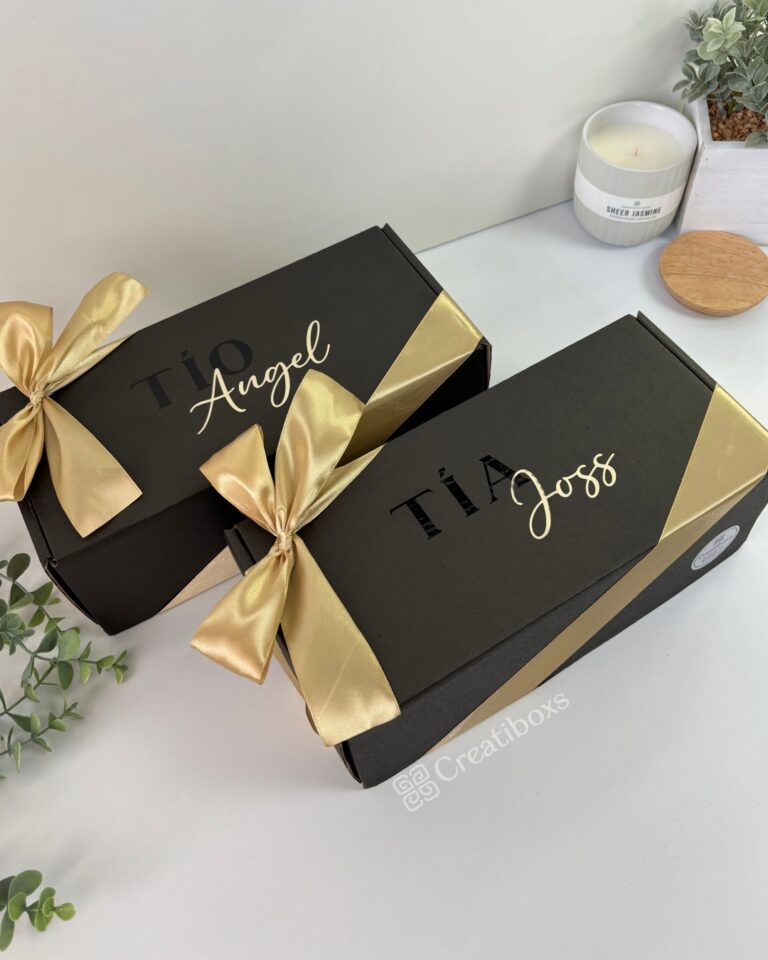 dos cajas color negro personalizadas con texto para padrinos y con moño color champaña