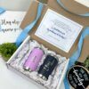 caja color blanco con moño azul y mensaje para petcion de padrinos con dos termos personalizados como contenido uno color lila y otro color azul regalo para padrinos