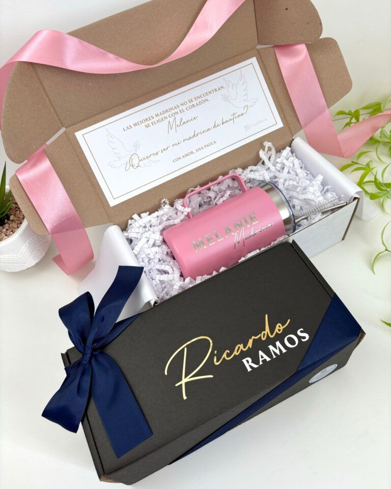kit de regalo para padrinos una caja abierta con un termo rosa personalizado para madrina y una caja cerrada con nombre de padrino en el exterior