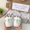 kit para padrinos dos termos color blanco con grabado personalizado nombres y palabras madrina y padrino y detras una caja de regalo con mensaje personalizado