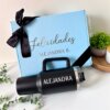 Un Kit personalizado termo jumbo 1200ml y caja mediana en color azul y negro, ambos con el nombre Alejandra.