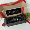 Kit de regalo con termo portalatas 420ml y caja personalizada, papel triturado negro, tarjeta de cumpleaños en español y listón rojo.
