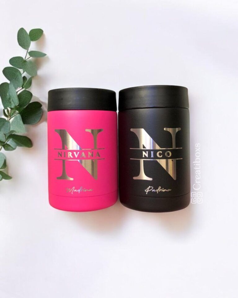 Dos recipientes cilíndricos uno al lado del otro sobre un fondo blanco. El recipiente de la izquierda es de color rosa brillante con las palabras NIRVANA y Marious en texto dorado. El recipiente de la derecha es de color negro con las palabras NICO y Pacifino en texto dorado. A la izquierda hay hojas verdes.