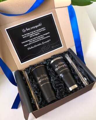 Caja de regalo abierta que incluye termos personalizados de Regalo de graduación, pajitas de metal y una tarjeta de felicitación con cinta azul: un regalo de graduación ideal.