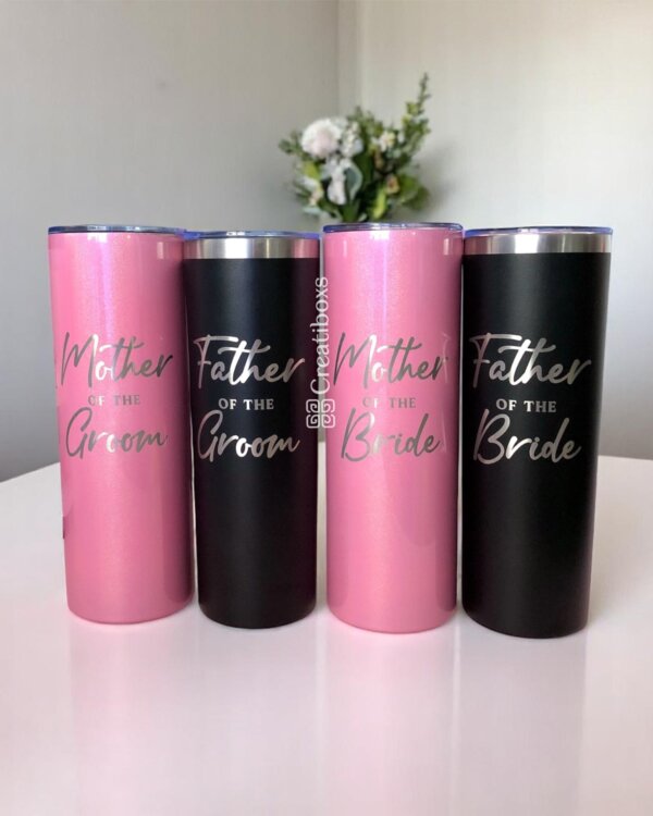 Cuatro "Termos personalizados para boda" etiquetados Madre/Padre del Novio/Novia en rosa y negro, exhibidos sobre una superficie blanca: regalos de boda únicos y recuerdos personalizados perfectos para su celebración especial.