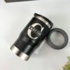 Termo personalizado portalatas 4 En 1 con destapador 420ml 14oz, color negro con nombre e inicial, y tapa gris separada, colocado sobre superficie blanca junto a una planta verde.