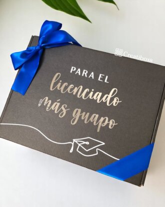 Una caja negra de termos personalizados de Regalo de graduación con cinta azul dice "Para el licenciado más guapo" y presenta una ilustración del birrete de graduación, perfecta para regalar termos personalizados.