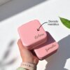 Una mano sostiene dos minicajas rosas Joyero personalizado de cuero sintético etiquetadas "Nahara" y "Samantha" en letras doradas metalizadas, ideales para regalar u organizar joyas.