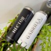 Los Termos personalizados para boda, identificados como Héctor Groom y Gabriela Bride con fecha de la boda, lucen perfectos para celebraciones nupciales y se muestran entre plantas verdes.