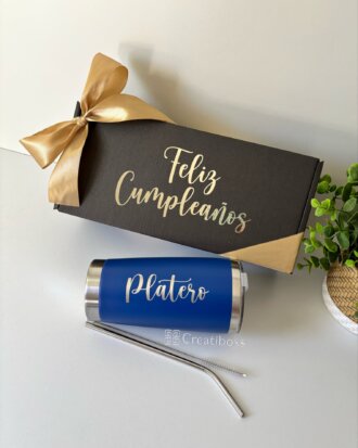 Pequeña caja de regalo personalizada con la etiqueta "Feliz Cumpleaños" y un lazo dorado, que incluye el vaso Platero Kit termo clásico de 590 ml y una pajita de metal, todo organizado en una elegante caja chica personalizada.