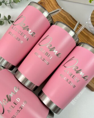 Cuatro termos personalizados para boda de color rosa, hechos de acero inoxidable con tapas plateadas, muestran nombres, rol de damas de honor o bridesmaids y fechas personalizados en una escritura elegante, ideales como recuerdos de boda.