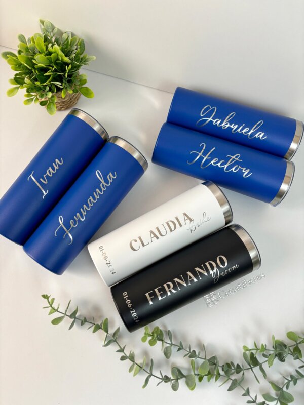 Seis termos personalizados para boda etiquetados con nombres, exhibidos sobre una superficie blanca con plantas verdes, ideales como obsequios de boda únicos o un obsequio de boda considerado.