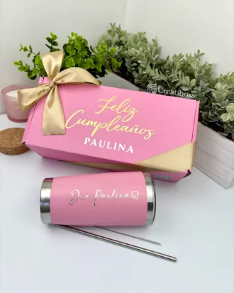 Kit termo clásico 590ml y caja chica personalizada en rosa con lazo dorado, incluye vaso termo y popote; fondo de plantas verdes.
