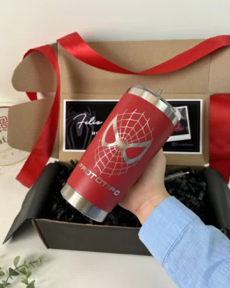 Una mano sostiene un vaso rojo con un diseño plateado de Spider-Man sobre la palabra PROTOTIPO, frente al Kit termo clásico 590ml y caja chica personalizada y su caja de regalo.