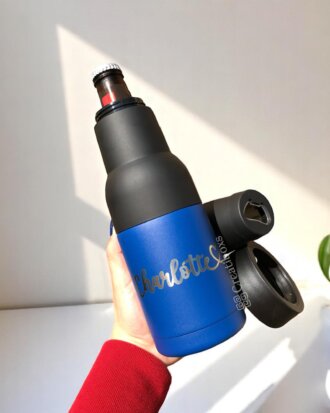 Una mano sostiene un termo personalizado azul con nombre y accesorios, ideal como Regalo del día del padre con caja personalizada.