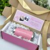 El Kit termo clásico 590ml y caja chica personalizada viene con una tarjeta de cumpleaños y fotos, arregladas con relleno de papel blanco y terminadas con una cinta dorada.