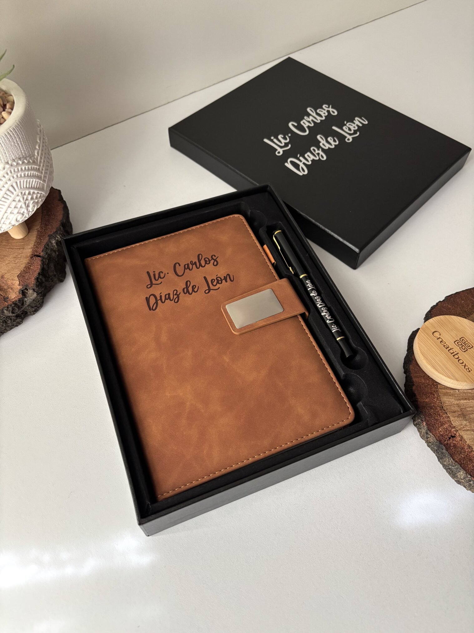 Set libreta con broche magnético plateado y bolígrafo negros en caja personalizada, ambos grabados con Lic. Carlos Díaz de León.