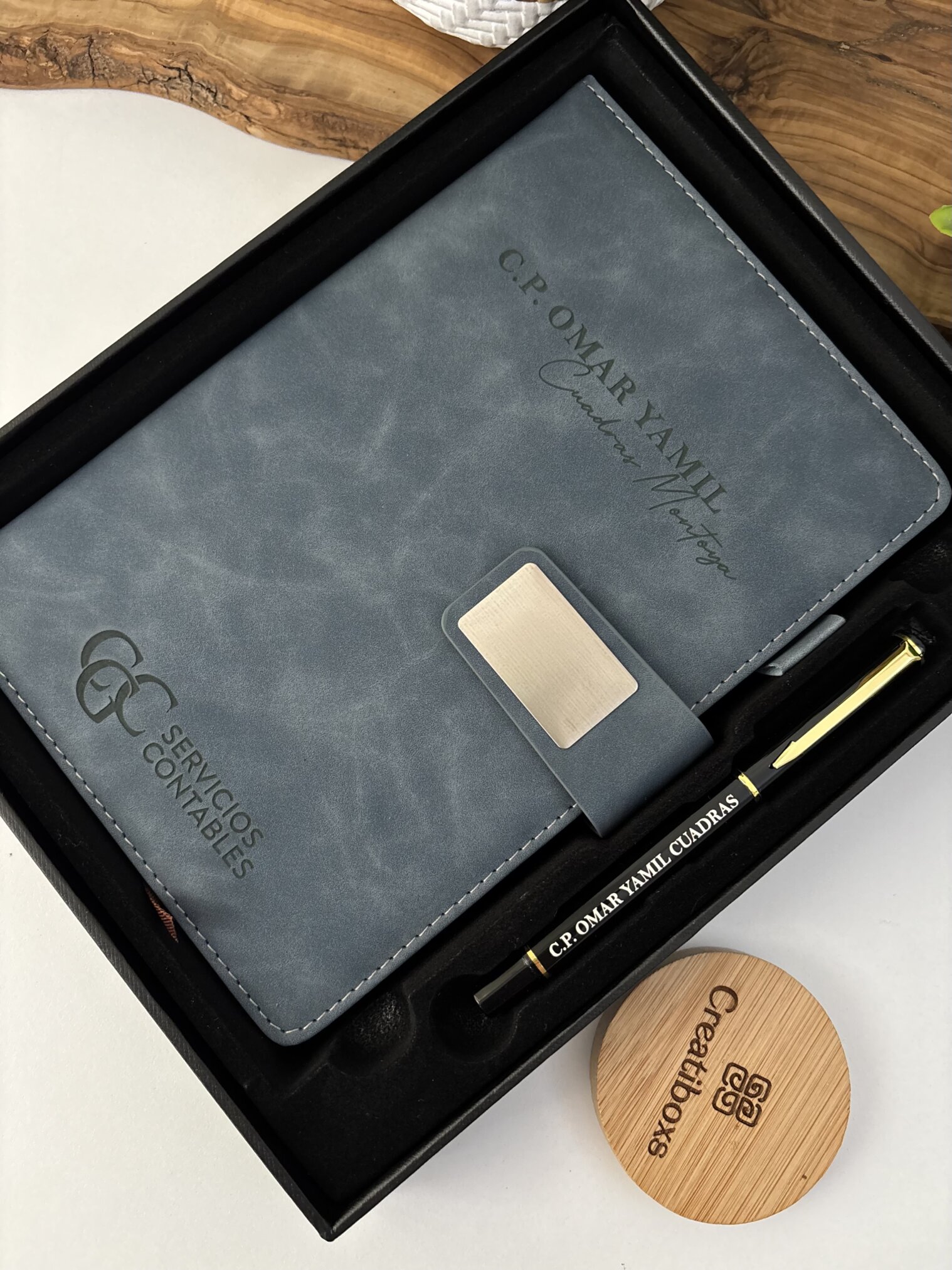 Elegante set libreta con broche magnético plateado y bolígrafo en caja, personalizado con Servicios Contables y C.P. Omar Yamil Cuadras.