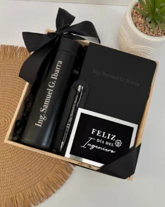 Kit regalo termo digital liso 500ml, libreta y bolígrafo personalizado con tarjeta "Feliz Día del Ingeniero", junto a una planta.