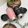 Dos termos-nevera personalizados -uno rosa (Nina Katia) y otro negro (Nino Adrian)- con decoración vegetal, presentados en una bonita cajita magnética personalizada.