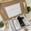 La caja de regalo incluye un "Kit porta botellas + termo delgado 590ml y caja personalizada md" personalizado, una nota, una cinta y pequeñas plantas decorativas cerca.