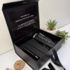 Un kit negro de regalo personalizado en caja incluye un termo delgado de 590 ml, un cuaderno vertical con cierre magnético y un bolígrafo, expuestos junto a pequeñas macetas sobre una superficie blanca.