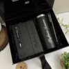 Kit de regalo personalizado en una caja negra con un termo delgado de 590 ml, un cuaderno vertical con cierre magnético y un bolígrafo, todo ello con la etiqueta Stephanie Heymez.