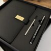 Set agenda personalizado con broche rectángulo dorado y bolígrafo en caja, presentado sobre una mesa de madera.