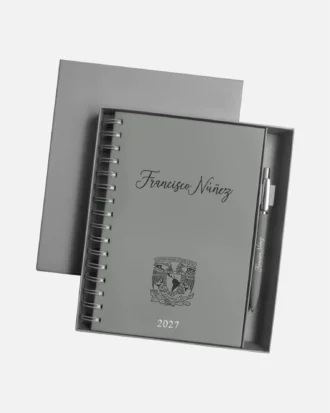 Agenda diaria 2027 con bolígrafo y estuche, de color gris, personalizada con el nombre «Francisco Núñez» en la portada.