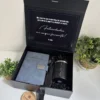 Kit personalizado en caja negra con taza termo negra, libreta azul con broche metálico y bolígrafo.